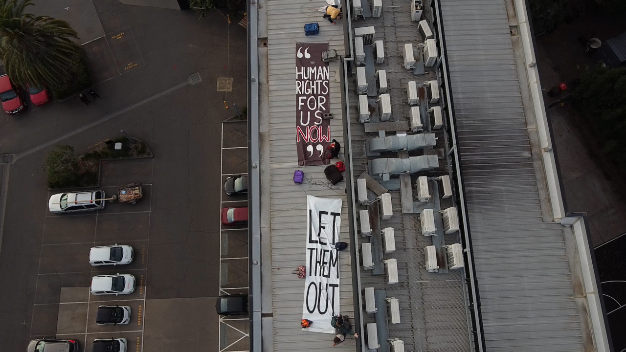 Refugee activists protest on the rooftop of the Preston hotel