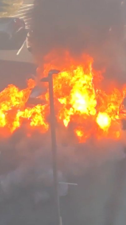 Wild moment burning car explodes in parking lot | Herald Sun